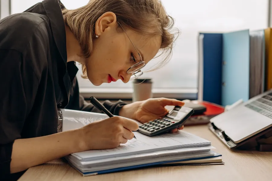 A restaurant owner working through accounts with a calculator