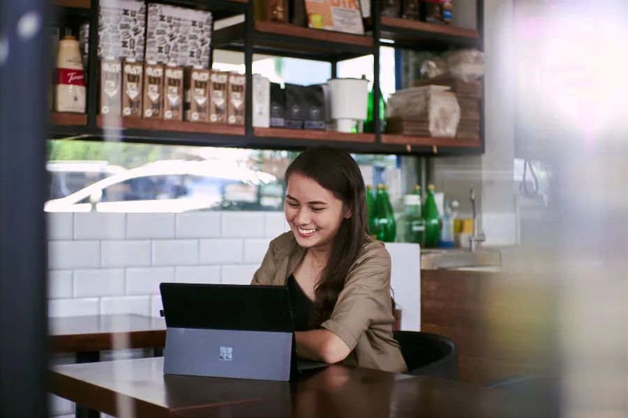 A café owner working on a laptop at the counter